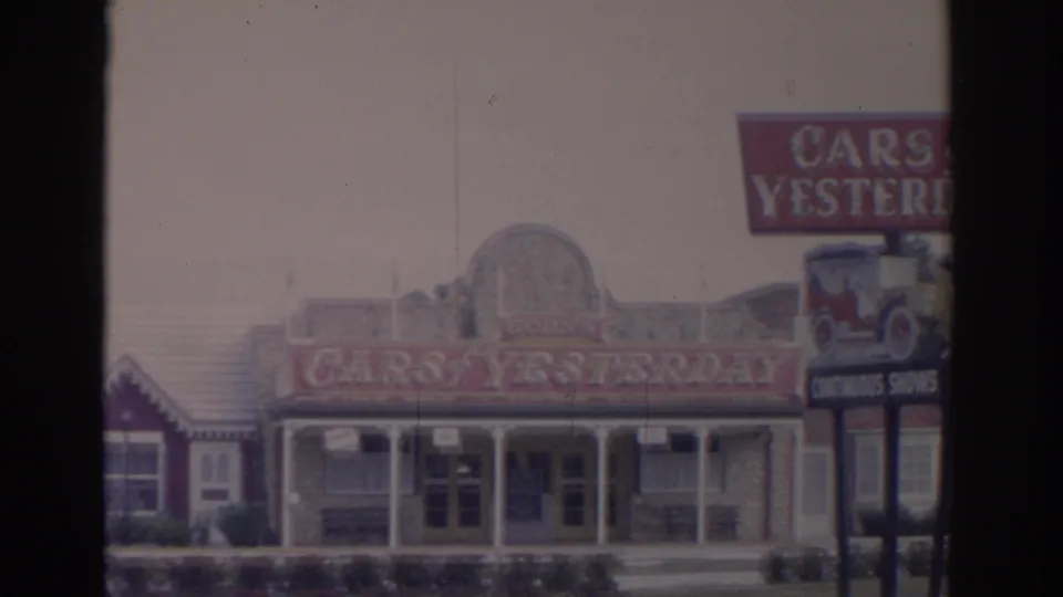 1962 Florida 8mm view of the Cars of Yesterday museum exterior with a roadside sign at the right edge.