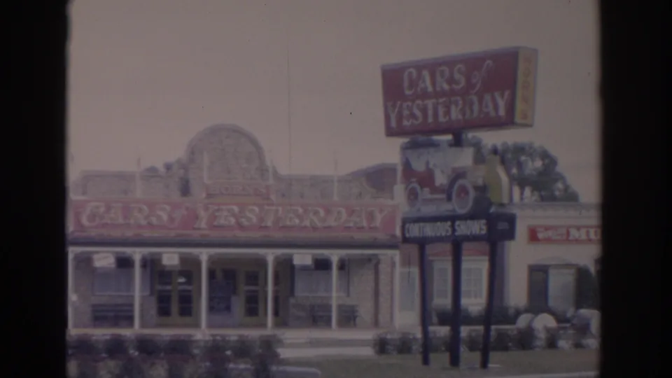 1962 Florida frame showing the Cars of Yesterday exterior and a large sign advertising continuous shows.
