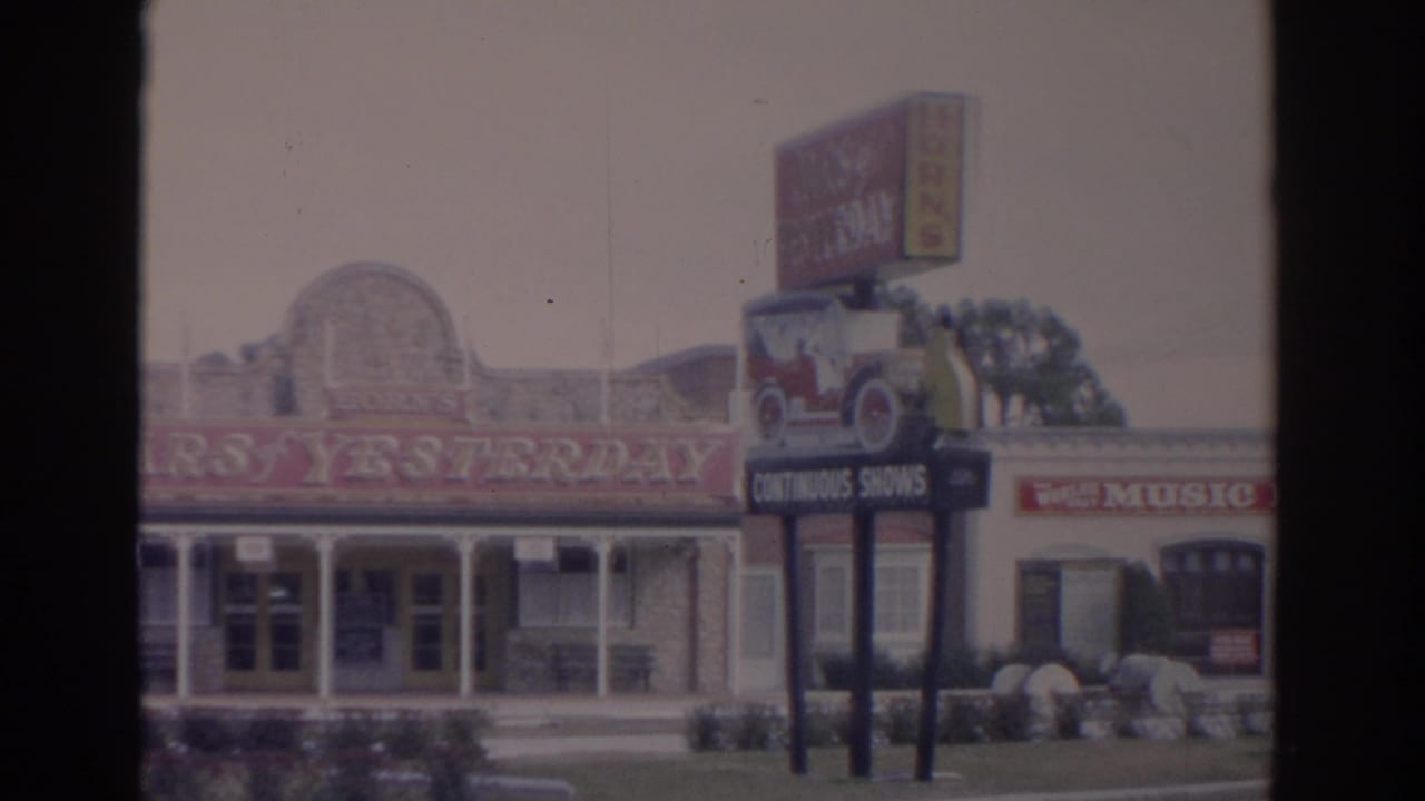 Roadside building with Cars of Yesterday lettering and a Music Fair sign above a classic car graphic.