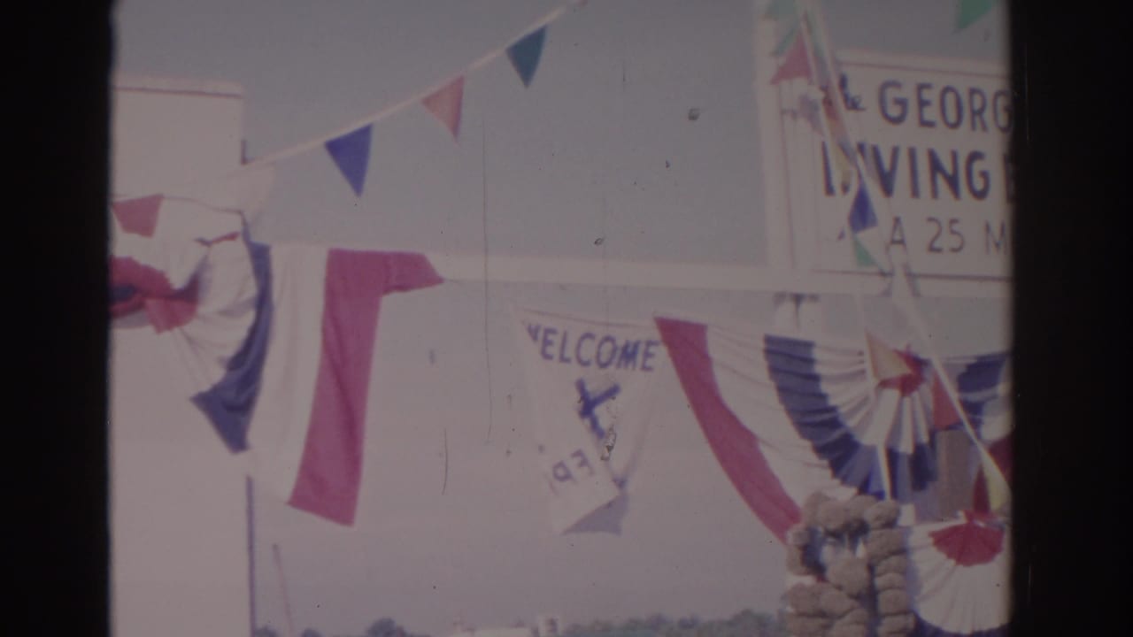 1962 Florida home-movie view of a decorated George Georgiou Diving Exhibition entrance with patriotic bunting and signs.