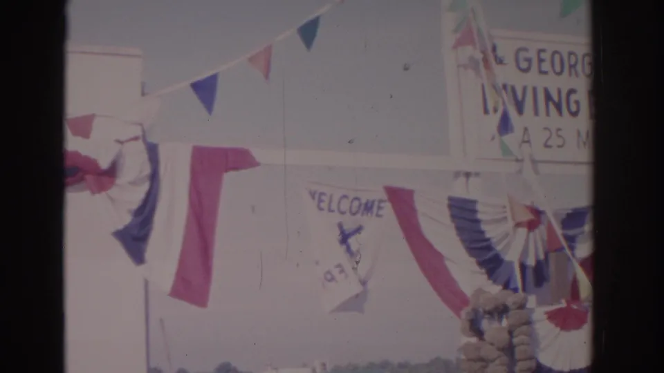 1962 Florida home-movie view of a decorated George Georgiou Diving Exhibition entrance with patriotic bunting and signs.