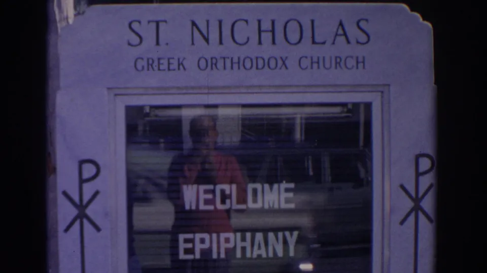 1962 Florida frame showing a St. Nicholas Greek Orthodox Church sign with WELCOME EPIPHANY lettering and religious symbols.