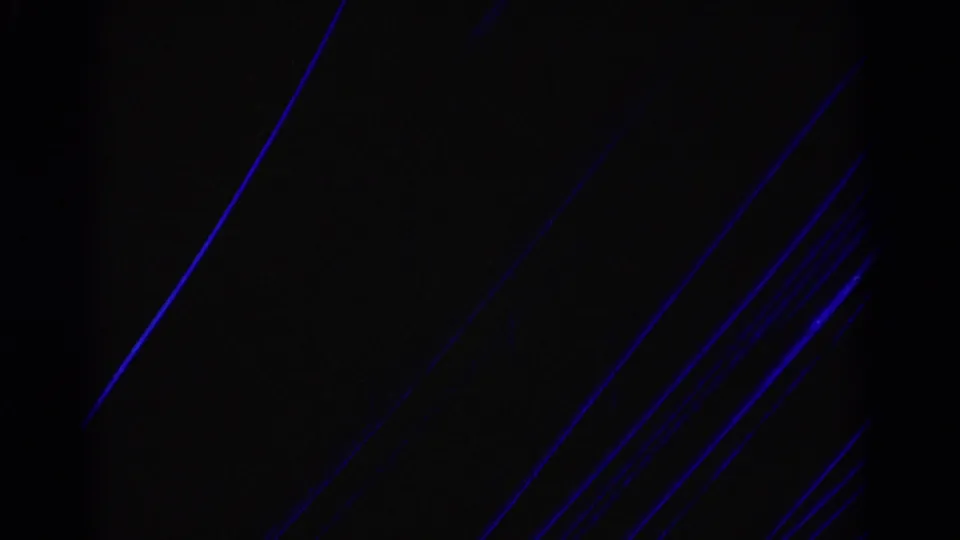 Underexposed or damaged 8mm frame area with blue scratch-like streaks and minimal readable parade detail from the contact sheet.