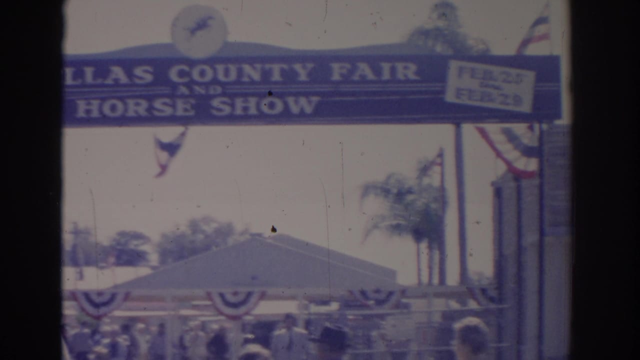 County fair and horse show entrance sign above a crowded outdoor fairground.