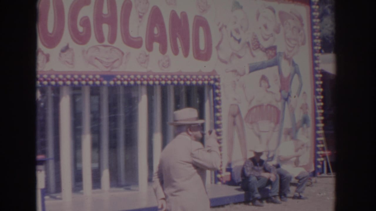 A man in a fedora appears to smoke a pipe near the Laughland booth while other fair visitors sit by the entrance.