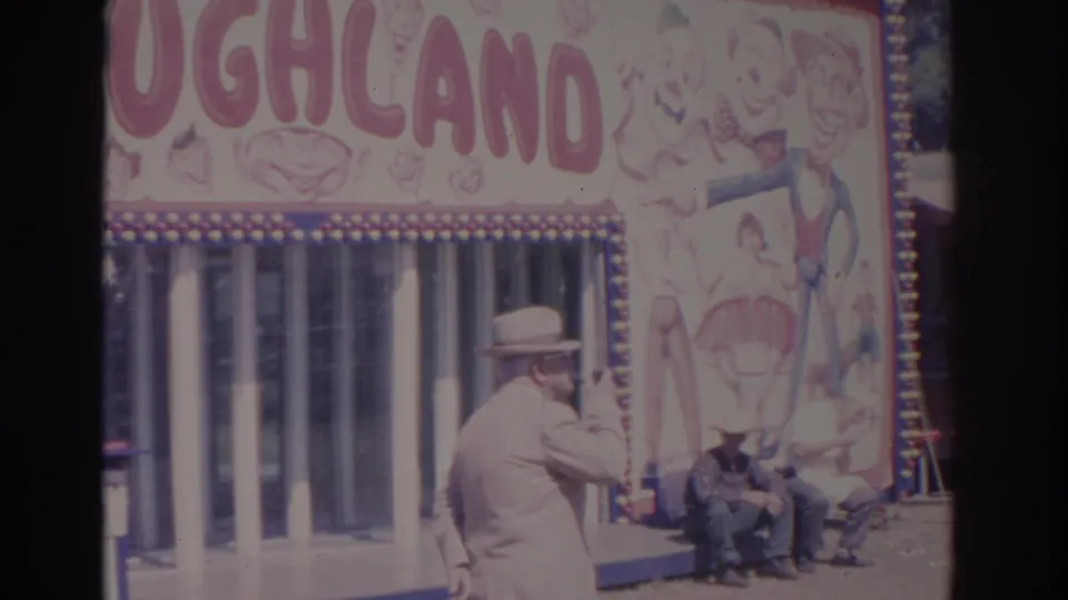 A man in a fedora appears to smoke a pipe near the Laughland booth while other fair visitors sit by the entrance.