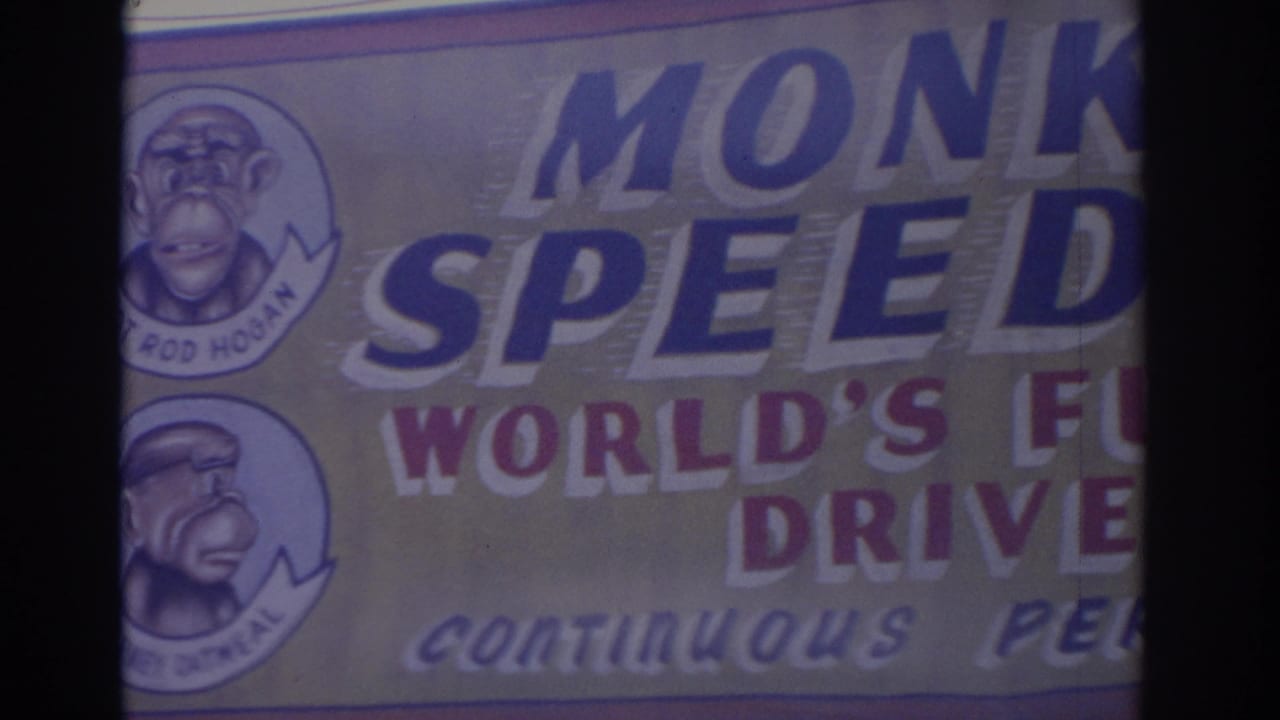 Close view of a Monkey Speedway sign with cartoon monkey driver medallions at left.