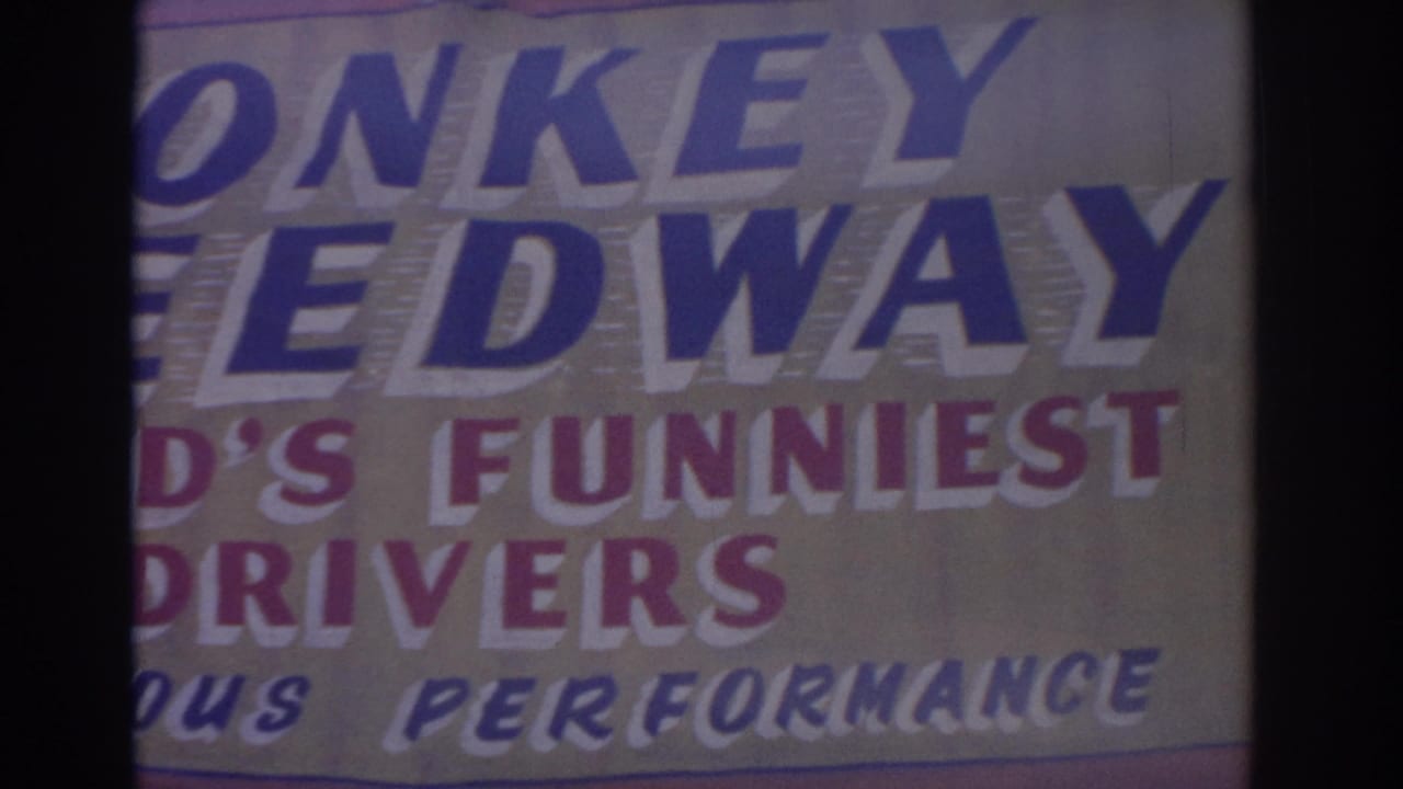 1962 Florida 8mm frame showing the lower left area of the Monkey Speedway sign, cropped around the large blue lettering.