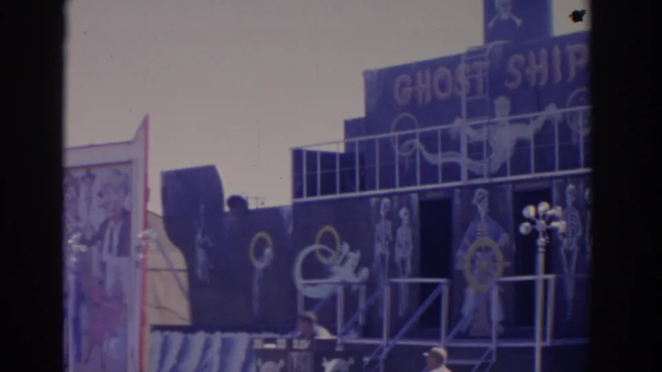1962 Florida fairground view of the Ghost Ship ride, showing a dark boat-like facade, sign lettering and skeletal artwork.
