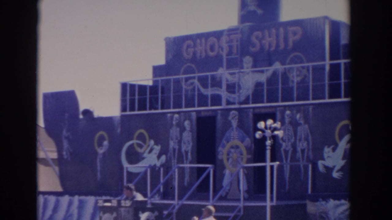 Florida 1962 home-movie frame centered on the Ghost Ship attraction, with skeletal paintings, railings and a dark blue boat facade.