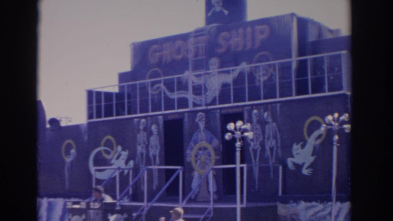 Dark Ghost Ship attraction facade with painted skeletons, ghosts, railings, and lamp posts.