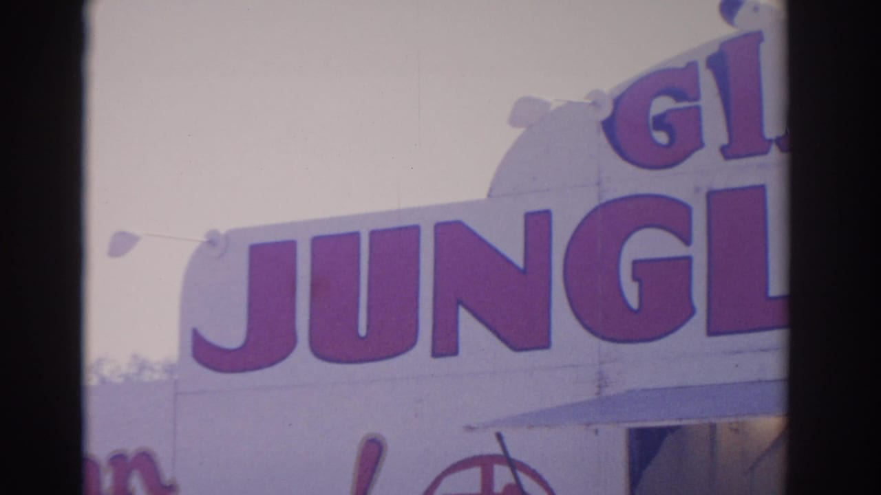 1962 Florida 8mm frame with oversized red Giant Jungle lettering on a bright carnival facade, partly cropped by the camera.