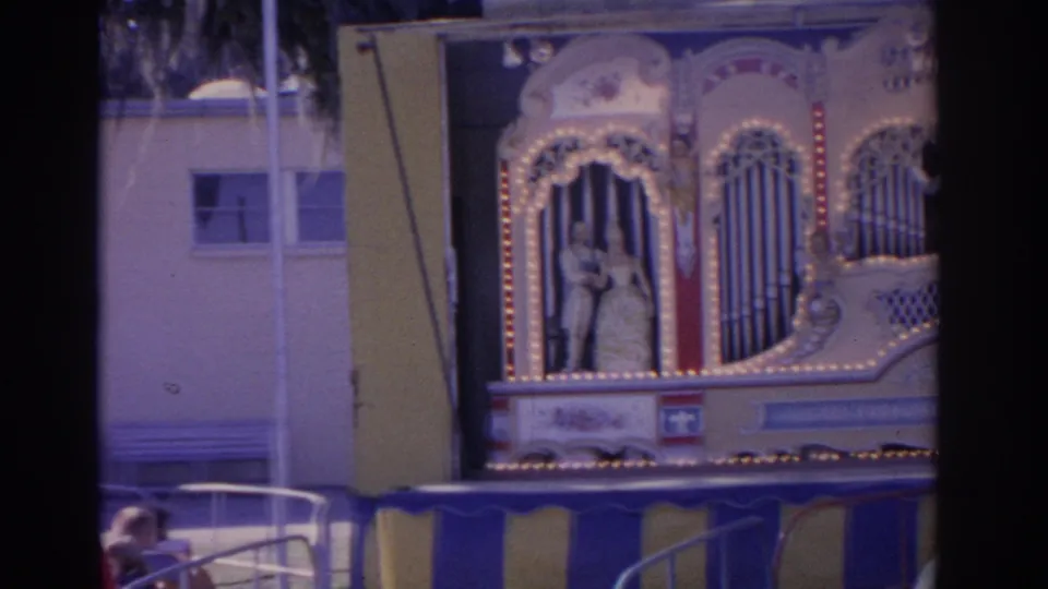 An ornate carnival attraction with lights, painted figures, and vertical decorative panels appears at the Florida fair in 1962.