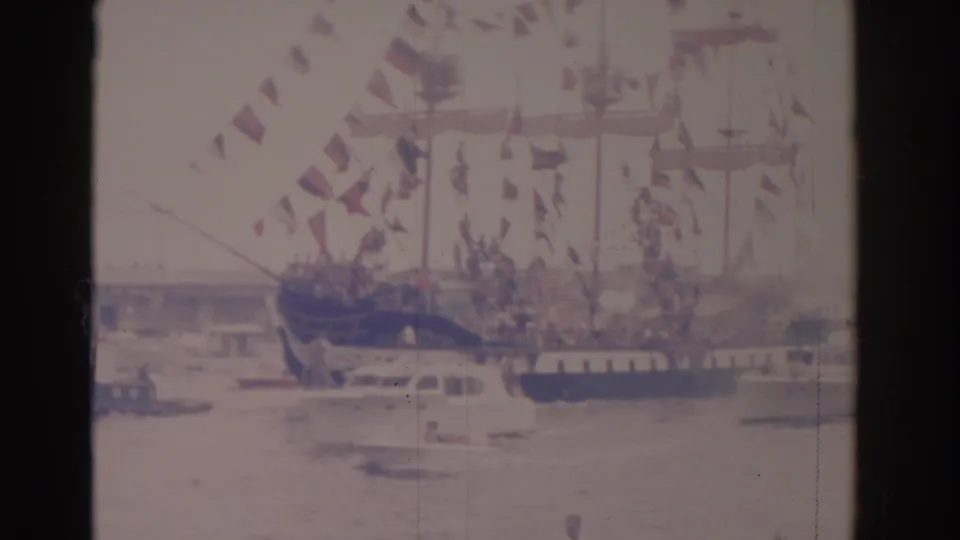 Faded 1962 Florida 8mm frame of a decorated ship and nearby boats during a harbor gathering.