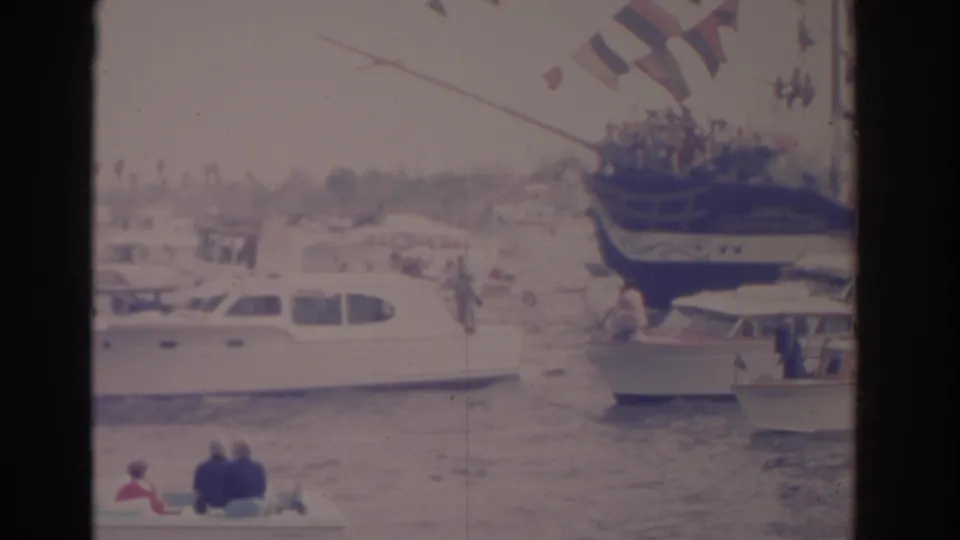 1962 Florida marina footage showing a large flag-dressed sailing vessel near white motorboats and small passenger boats.