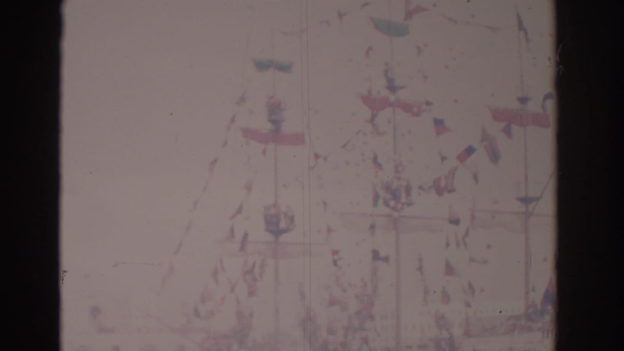 Faded view of a decorated ship with flags and mast lines under a bright sky.