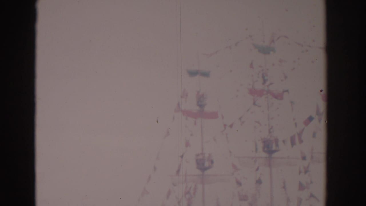 Distant ship with bunting and flags, partly washed out by bright exposure.