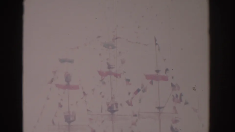 1962 Florida 8mm frame showing a decorated maritime scene with flags, mast lines, and distant people by the water.