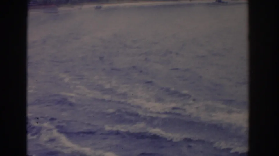 Soft 8mm frame of wake patterns and rippling open water during the Florida water-skiing scene.