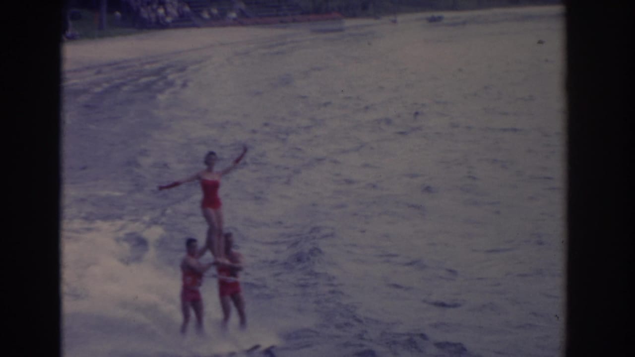 The 1962 Florida water ski act continues with one performer balanced above two others as wake spreads across the lake.