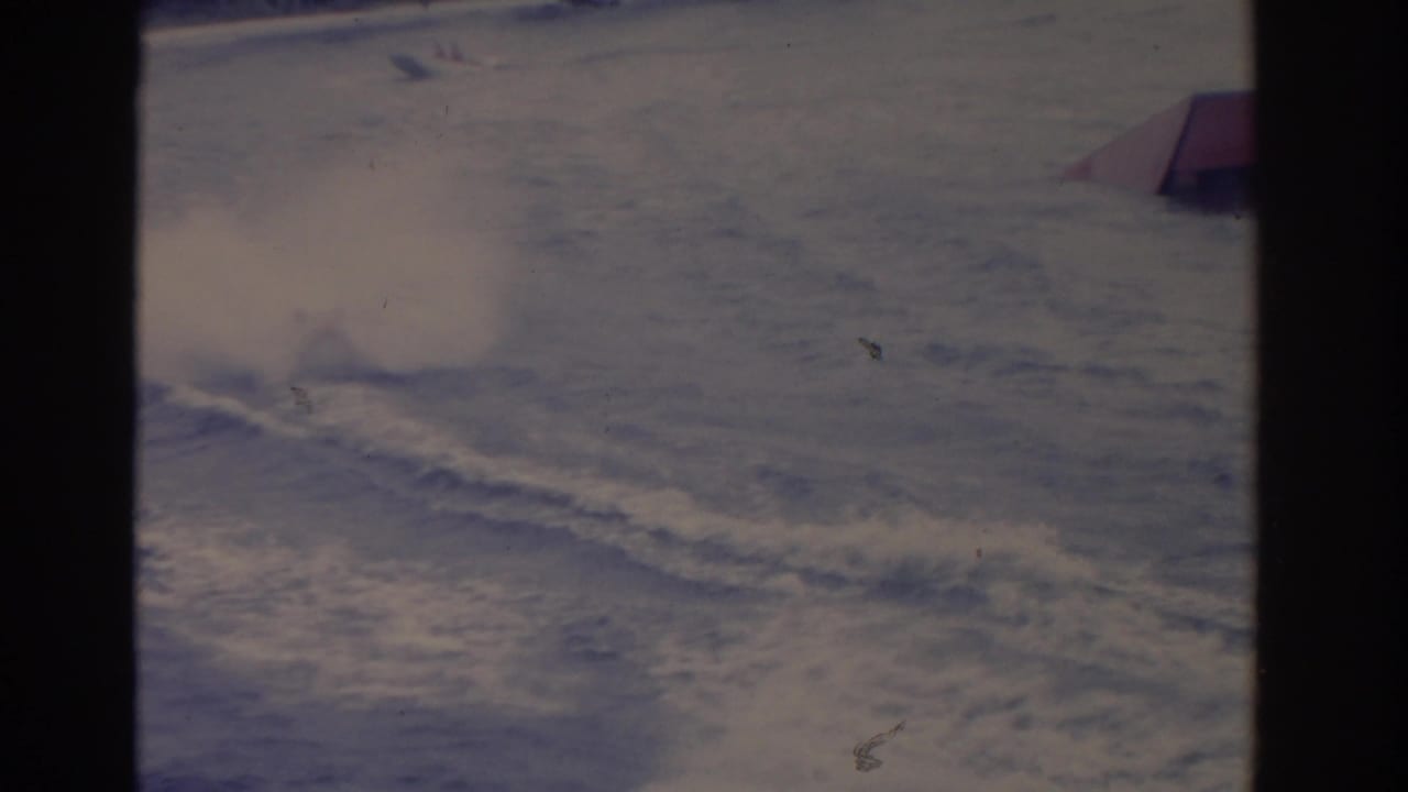 1962 Florida 8mm frame where the boat has passed near the edge, leaving turbulent wake and white spray across the water.