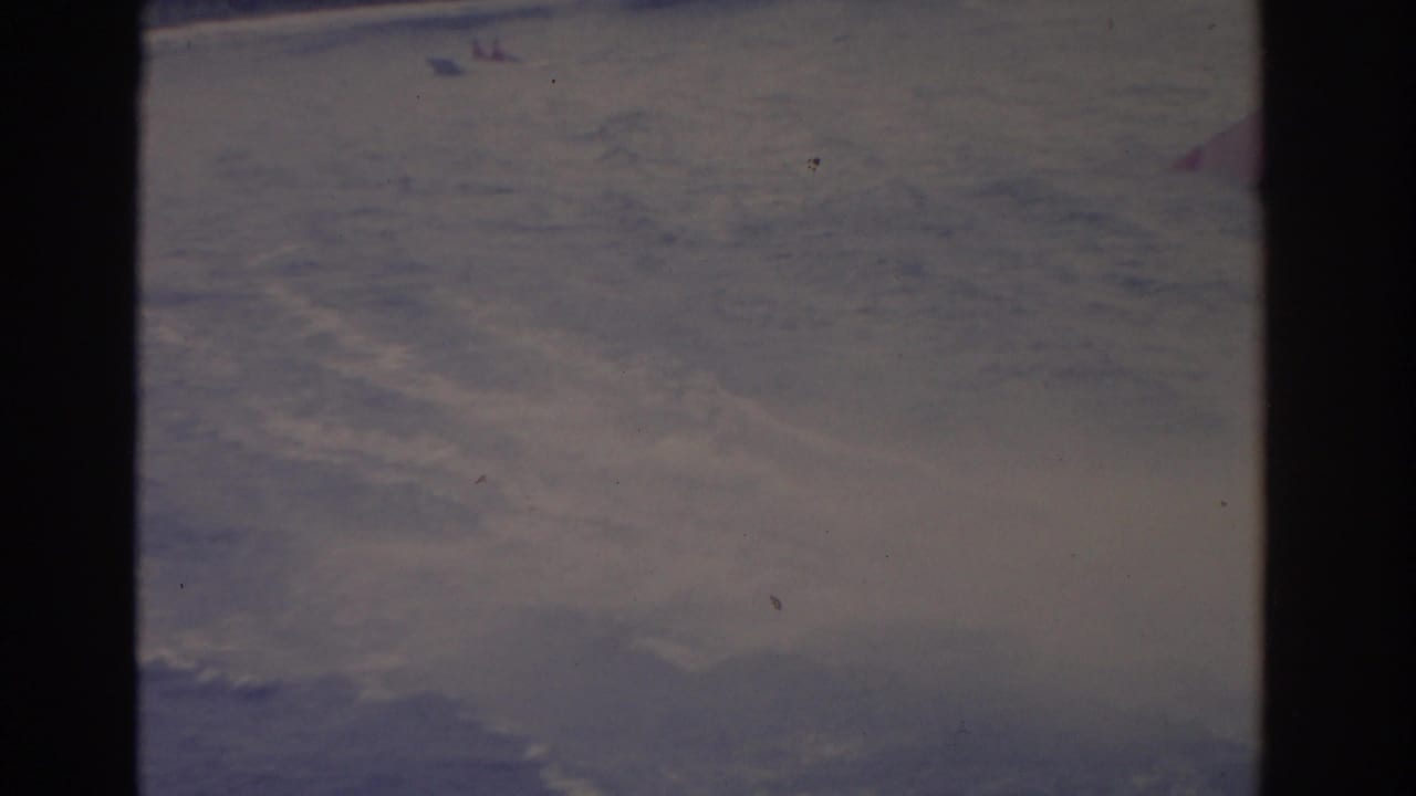 1962 Florida 8mm frame showing turbulent wake and spray after a motorboat passes across the water.