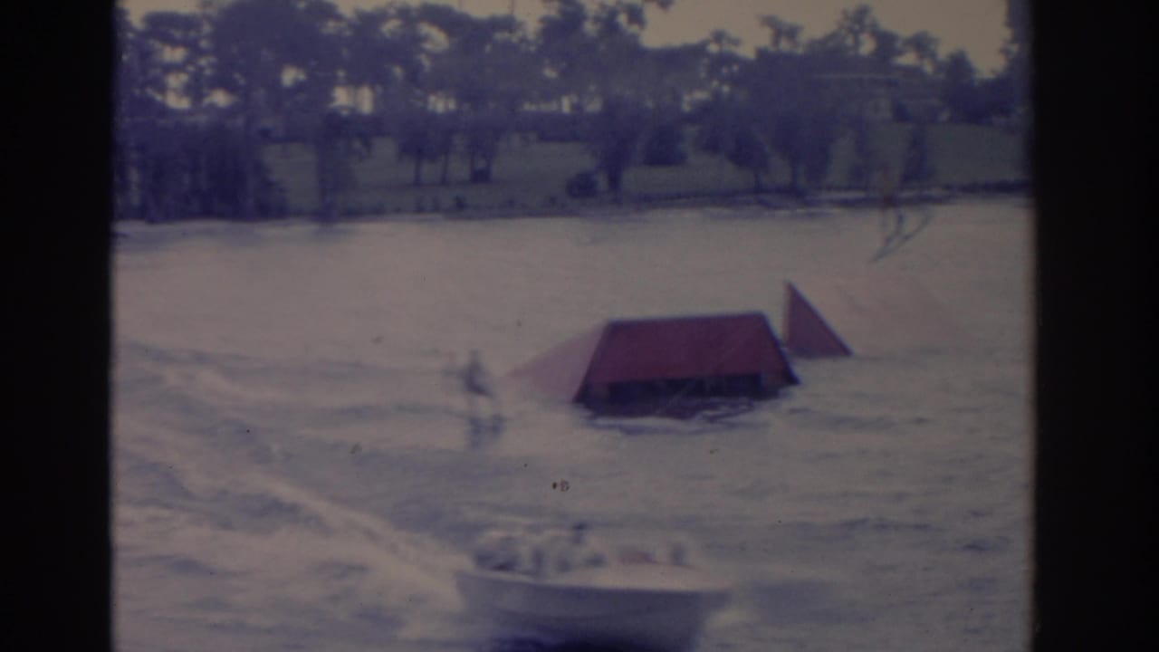 Choppy lake with a red water-ski ramp and a blurred boat near the lower edge.