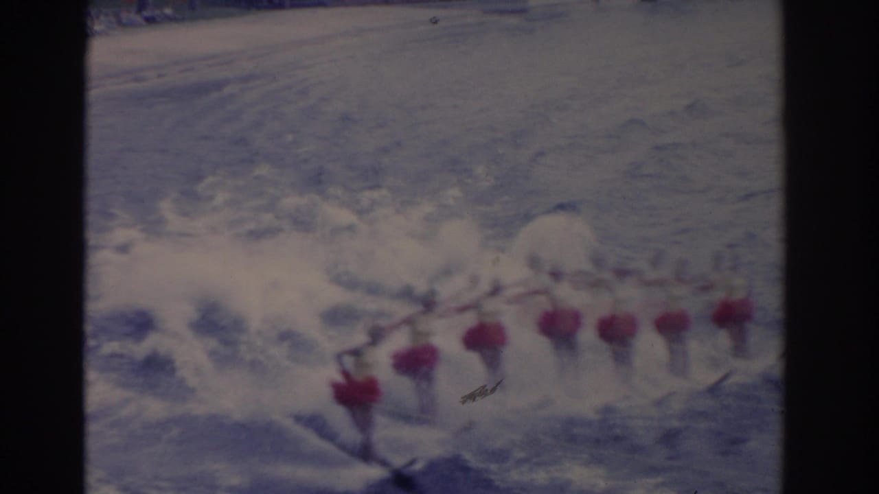 A group of female water skiers in matching costumes holds formation through foamy water in the Florida performance footage.