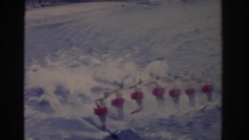A group of female water skiers in matching costumes holds formation through foamy water in the Florida performance footage.