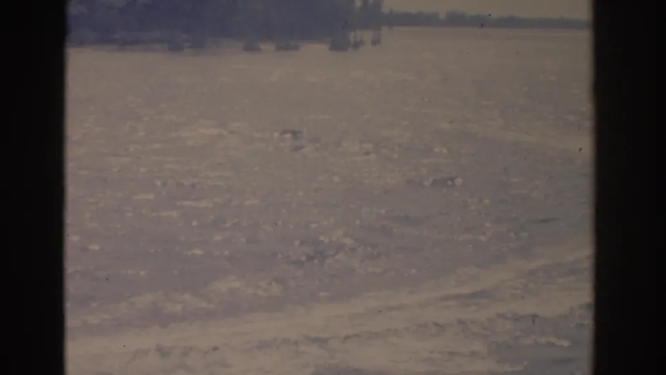 1962 Florida 8mm frame showing textured lake water, distant trees, and soft faded color from a boat perspective.