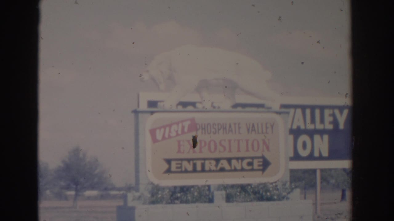 1962 Florida 8mm frame showing the Phosphate Valley Exposition entrance sign with a white bear figure above it.