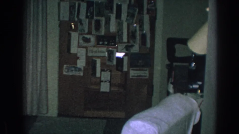 1962 Gary, Indiana interior showing a bulletin board crowded with photos and papers beside curtains and household furniture.