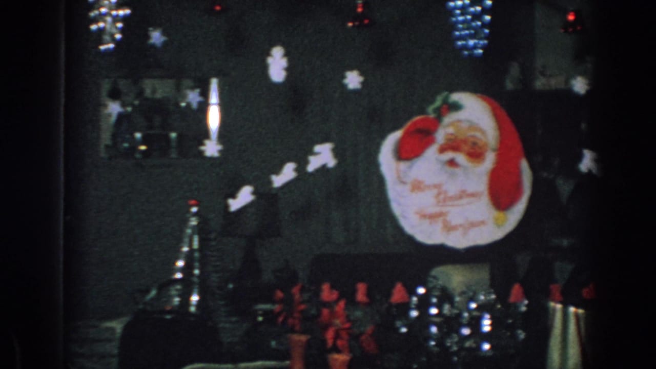 Dim holiday room with Santa face topper and hanging paper decorations.