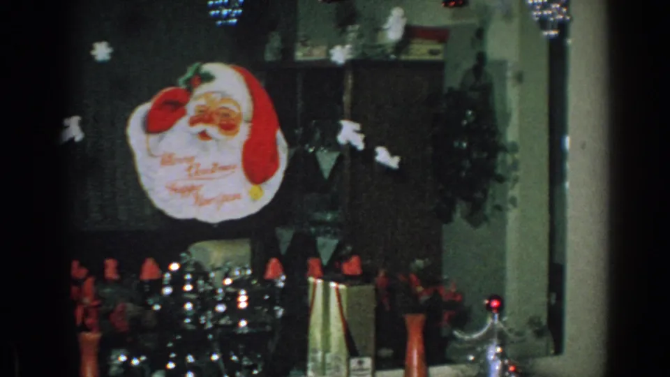1962 Gary, Indiana home interior with a silver Christmas tree, Santa face topper, red decorations, and paper cutouts overhead.
