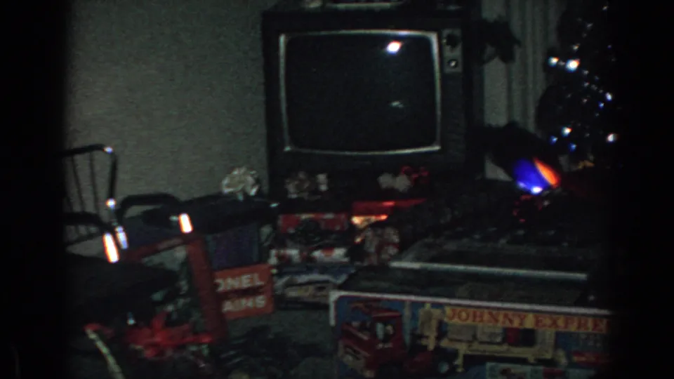 1962 Gary, Indiana living room with a vintage television, boxed toy gifts, and holiday decorations on the floor.