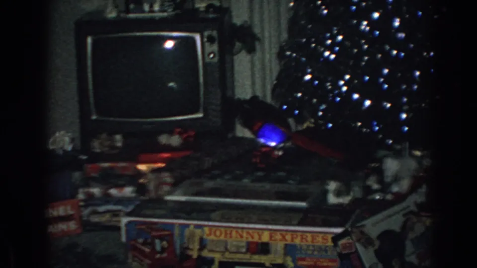 1962 Gary, Indiana living room showing a vintage television, lit Christmas tree, and boxed toys including readable packaging.