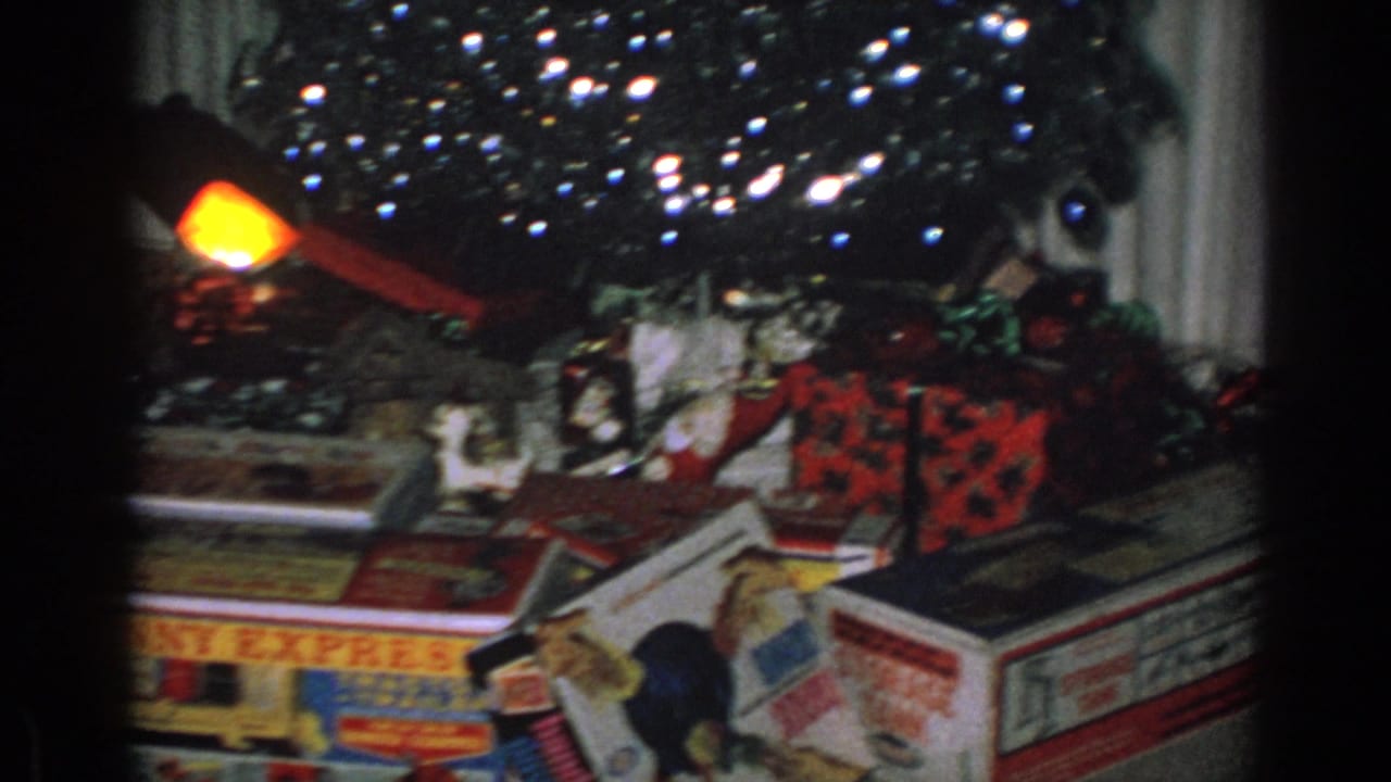 Wrapped presents and toy packaging under a Christmas tree with bright holiday lights.