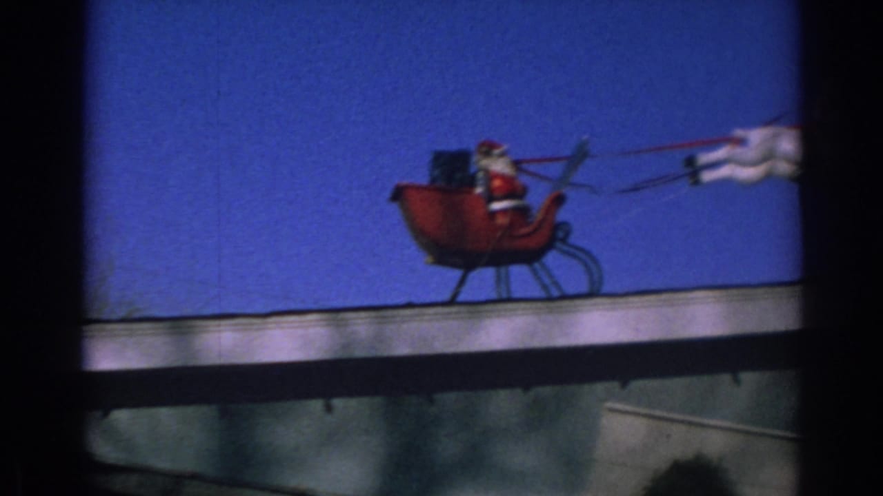 Santa figure in a red sleigh begins a rooftop reindeer display against blue sky.