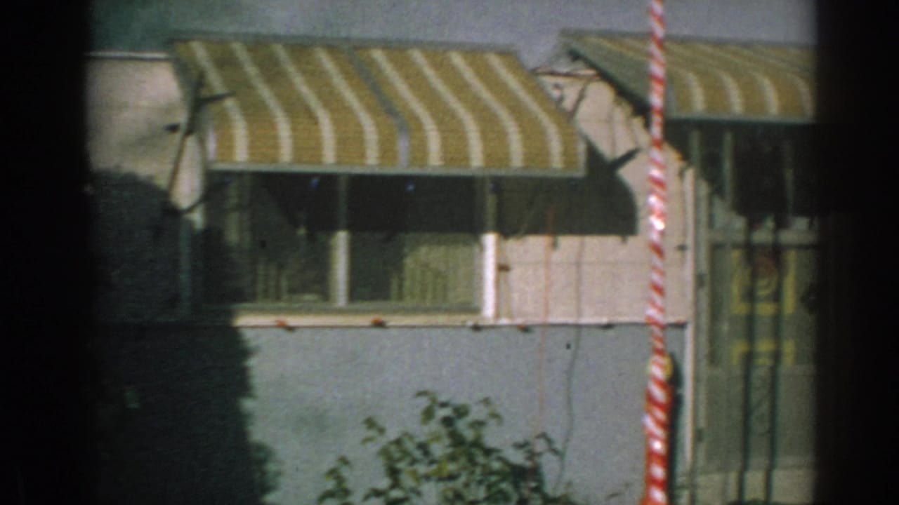 Striped awning over windows on a blue trailer home facade.