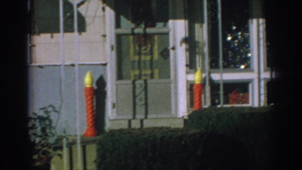 House exterior with large candle decorations beside front windows.