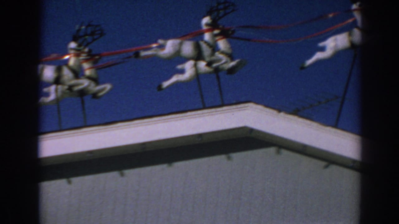 Rooftop reindeer display continues across the top of a building.