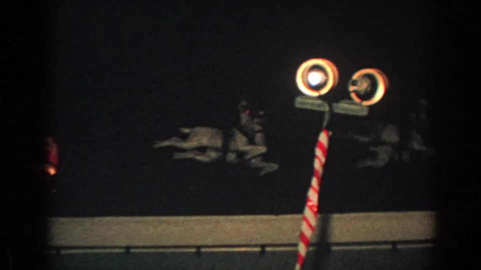 1962 Gary, Indiana 8mm frame showing circular lights, a striped pole, and reindeer silhouettes in a rooftop Christmas display.