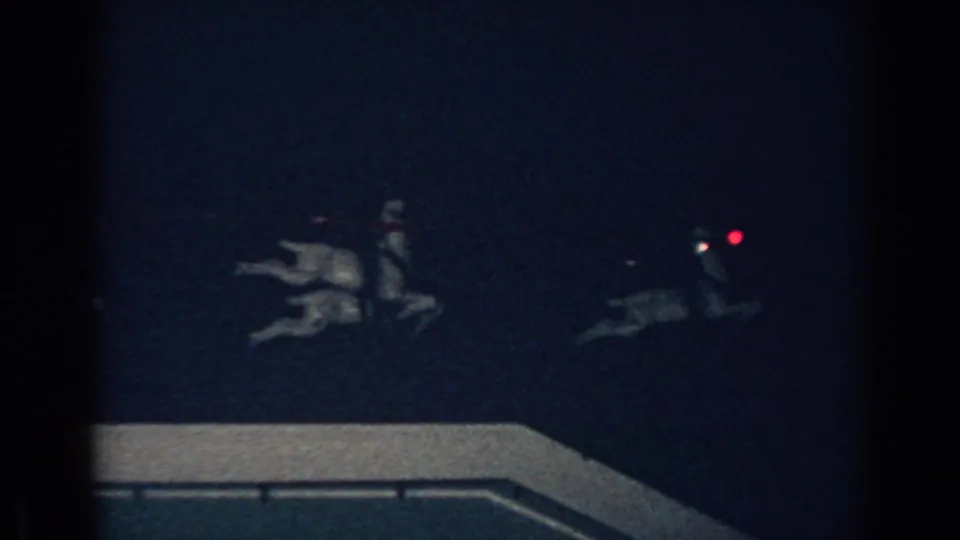Low-light 1962 Gary, Indiana frame showing reindeer figures with small red lights above the roof edge.