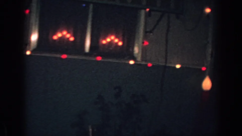 1962 Gary, Indiana nighttime frame with red Christmas lights outlining part of a house exterior.