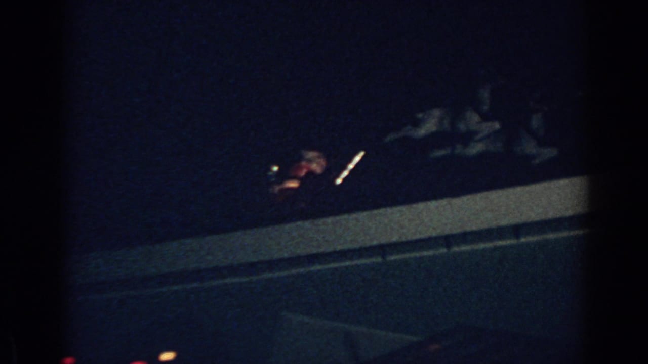 1962 Gary, Indiana frame with an illuminated Santa sleigh and reindeer decoration seen against a dark night sky.