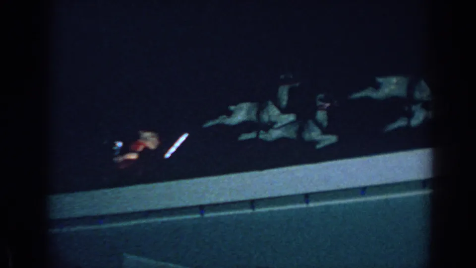 Low-light 1962 Gary, Indiana home-movie frame showing Santa, sleigh, and reindeer decorations along an exterior ledge.
