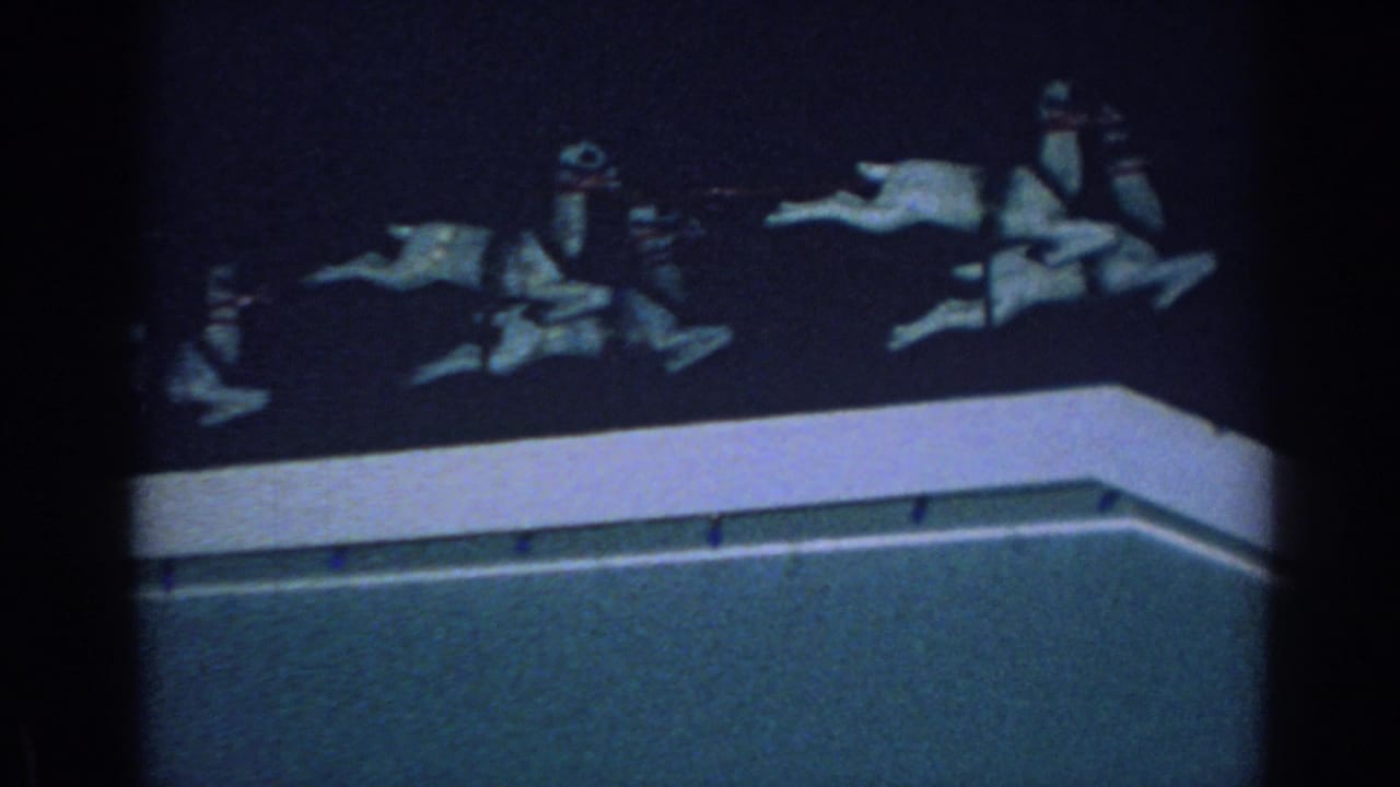 Illuminated reindeer figures on a rooftop against a dark night sky.