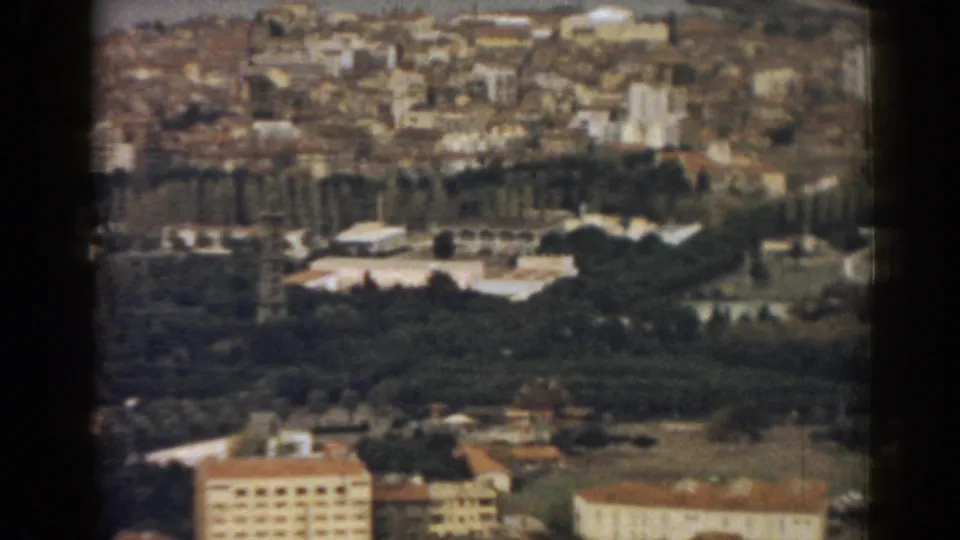 Late frame from the 1962 Izmir aerial scan, with dense urban buildings, trees, rooftops and pale structures below.