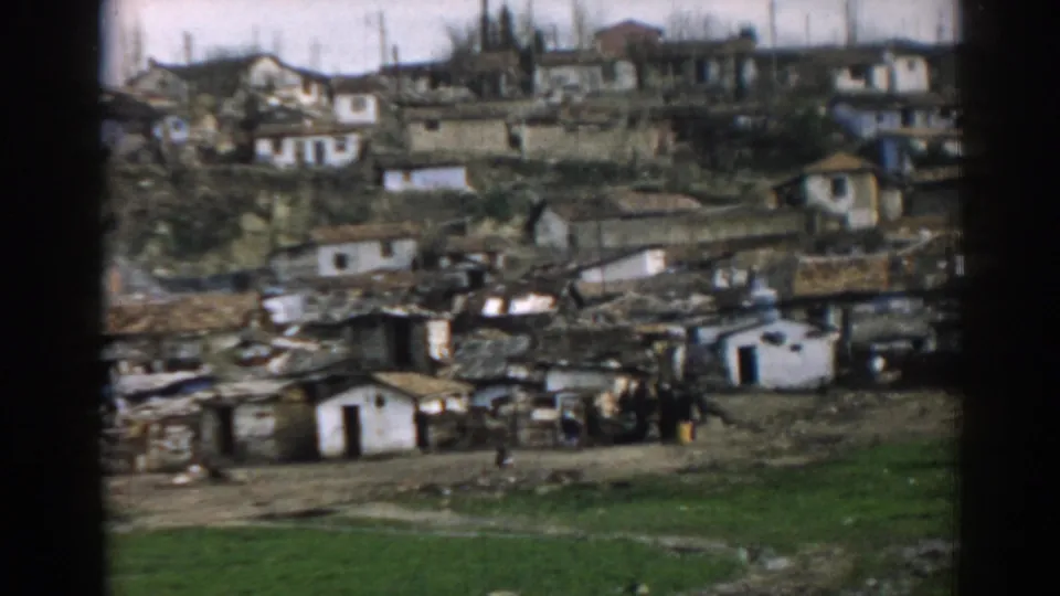 1962 Izmir view of closely gathered hillside dwellings with weathered roofs and open ground below.