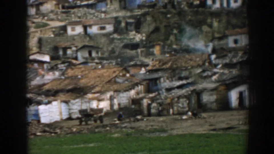1962 Izmir home-movie view of simple hillside housing, rough open ground, small figures and smoke in the settlement.